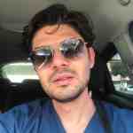 Male driver with sunglasses in a car, casual style, sunny day.